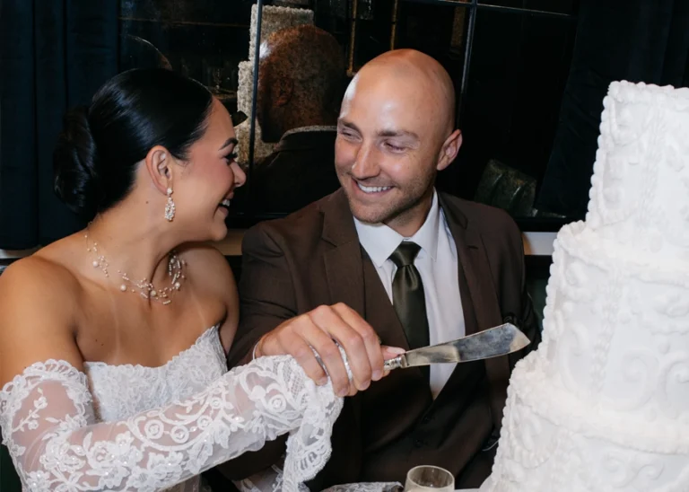 Bride and groom sitting next to a downtown window sill looking out at the street